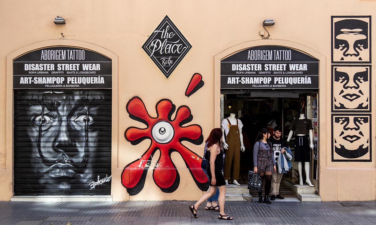 Gadekunsten pryder også Sohos butiksfacader, bl.a. skaterbutikken The Place Sohoi gaden Córdoba. Her er bl.a. værker af Spaniens mest berømte grafittikunstner, SUSO33, (i midten) og OBEY (th).
