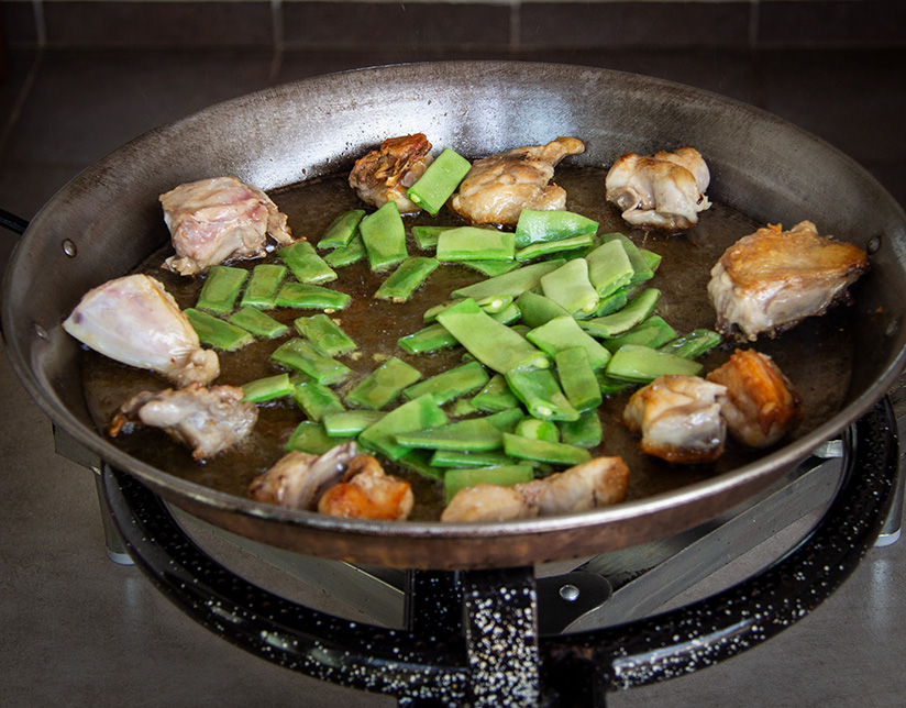 A classic paella is cooked over an open fire.
